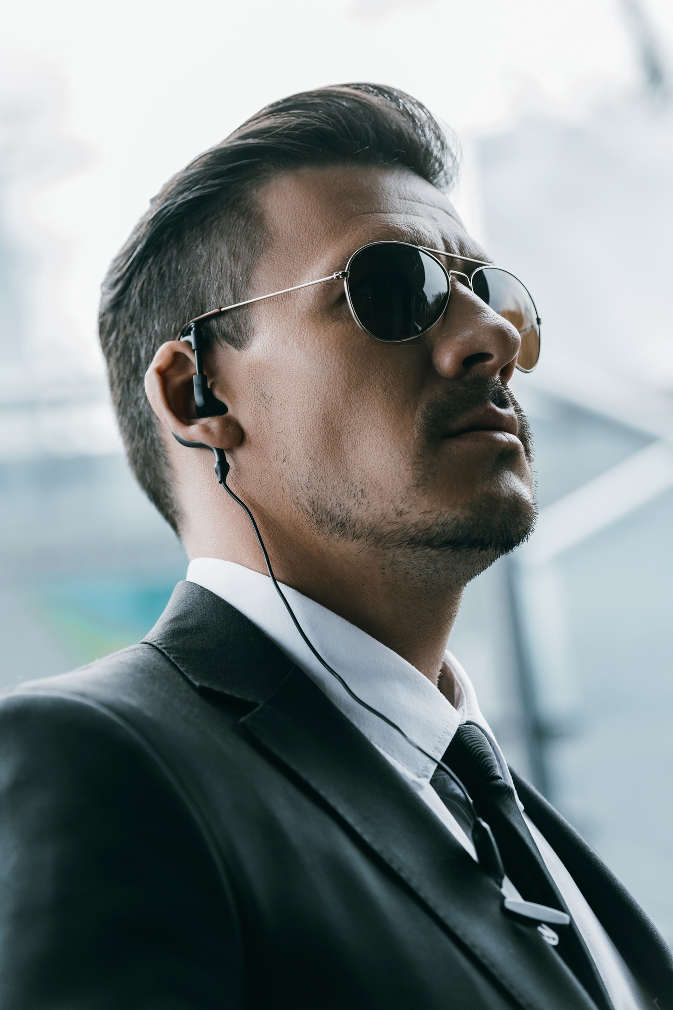 portrait of handsome security guard in sunglasses and security earpiece